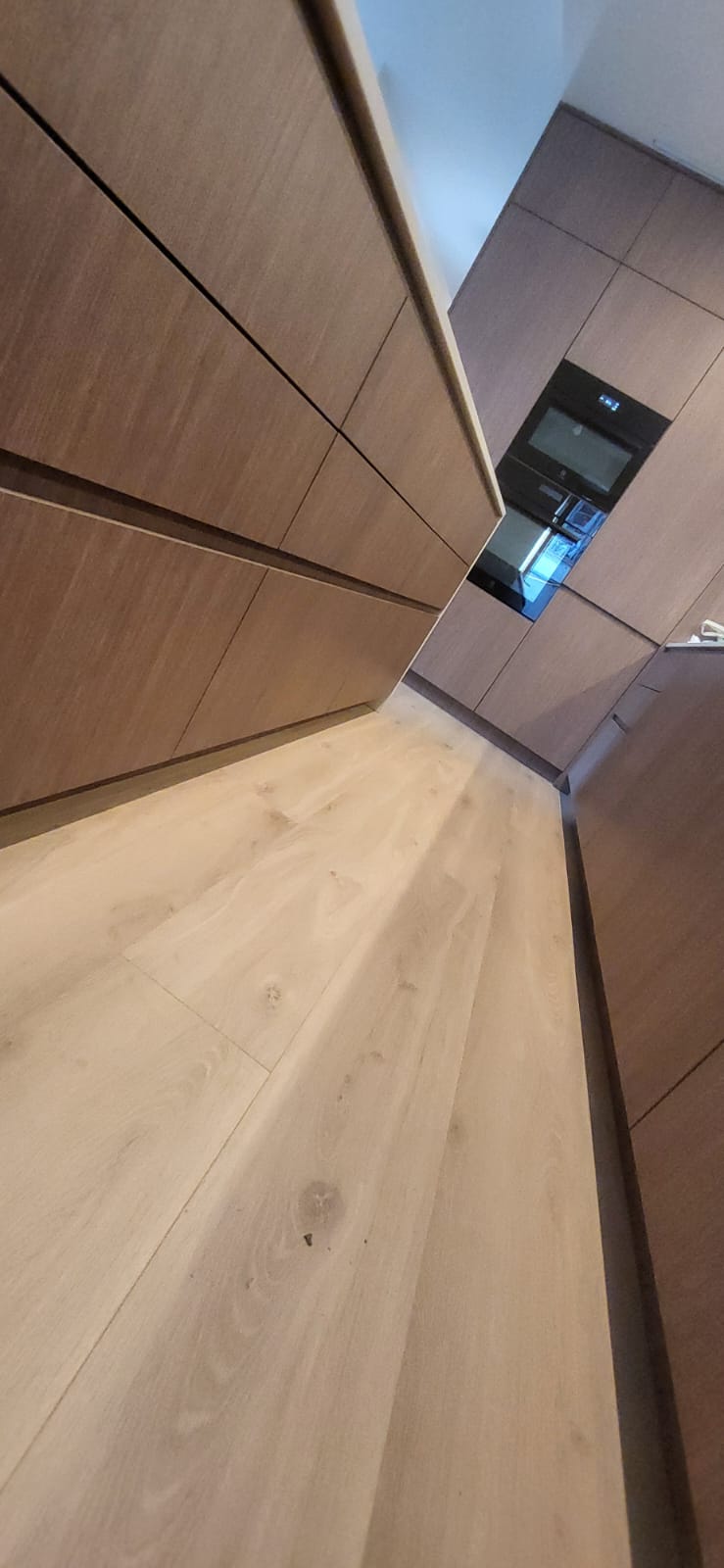Walnut handleless kitchen cabinets with new oak floor