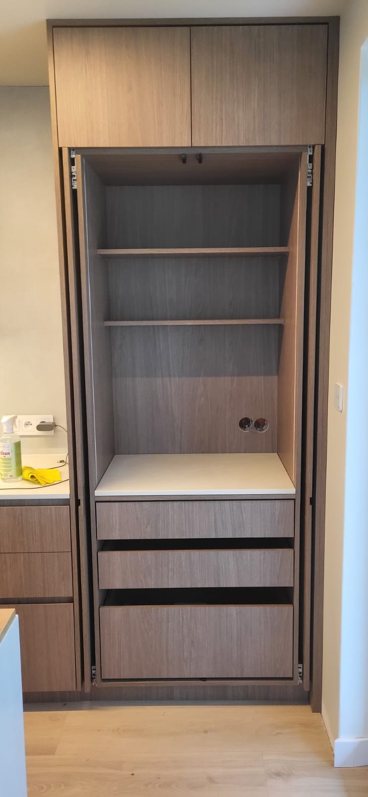 Open built-in storage cabinet with shelves and drawers