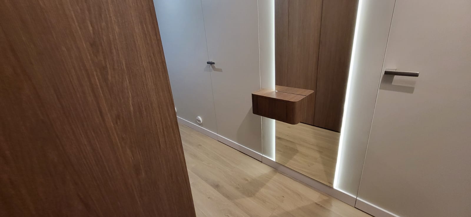 Entrance hall with full-height mirror and white joinery