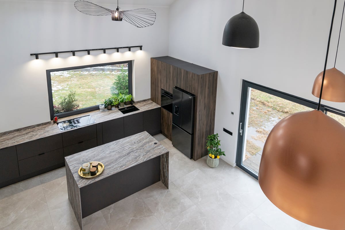 Aerial kitchen view with copper pendant lights and stone island