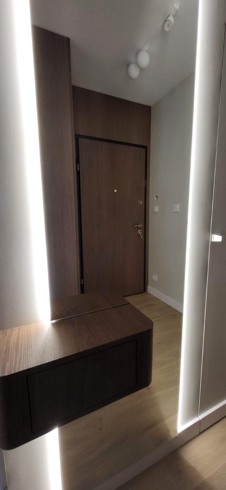 Entrance hall with illuminated mirror panels and walnut console
