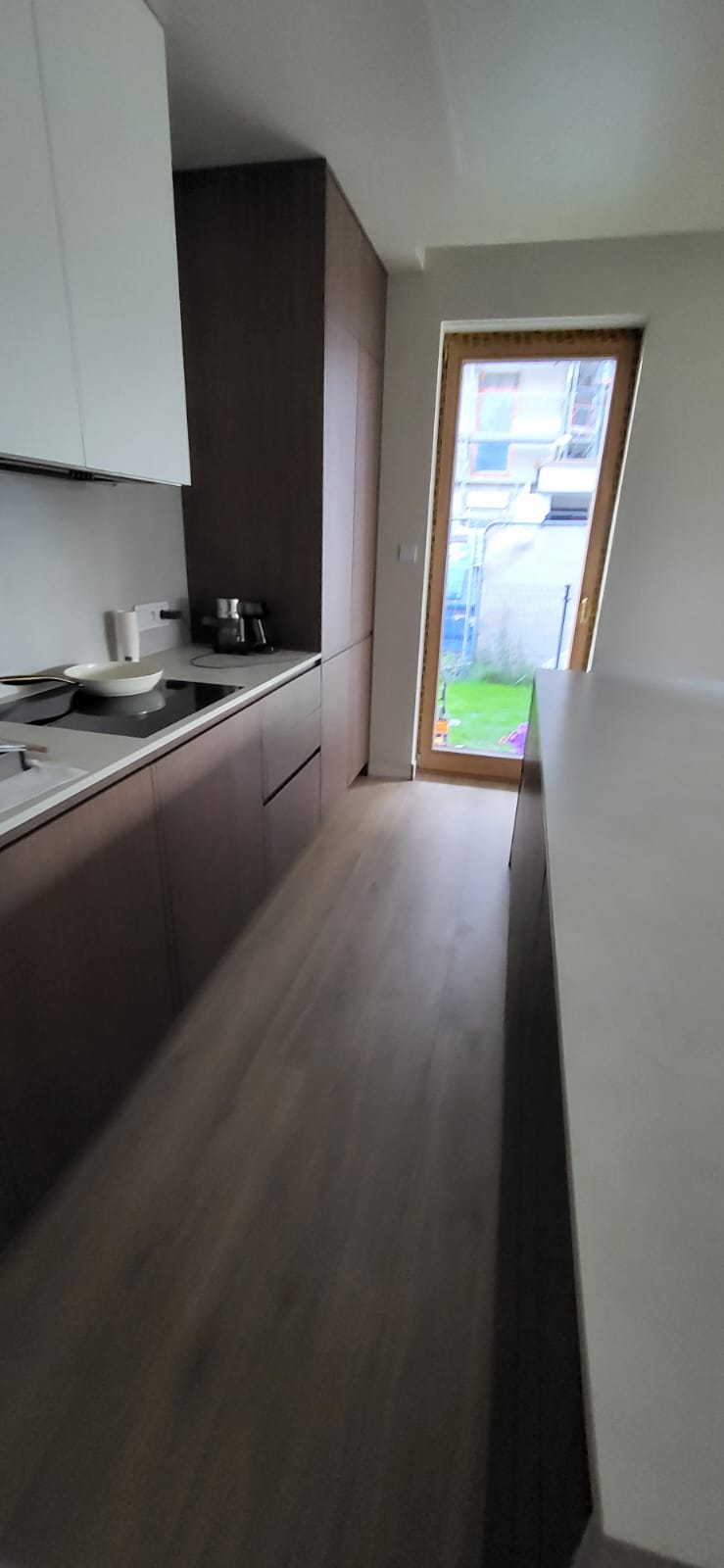 Galley kitchen with white and walnut cabinets