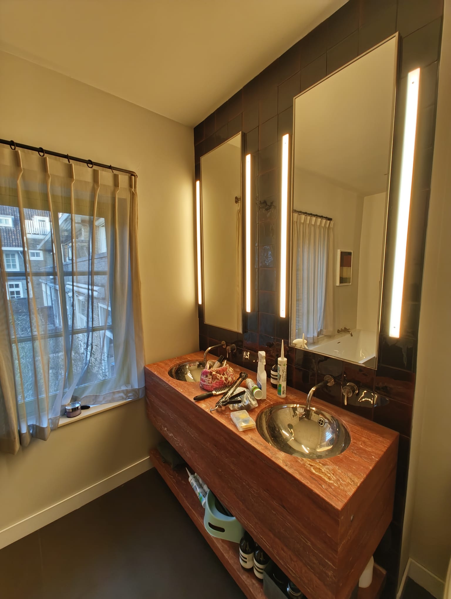 Double vanity with wood top and lit mirror panels