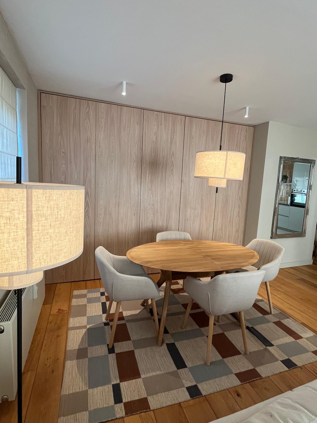 Dining area with oval table and full-wall built-in wardrobe