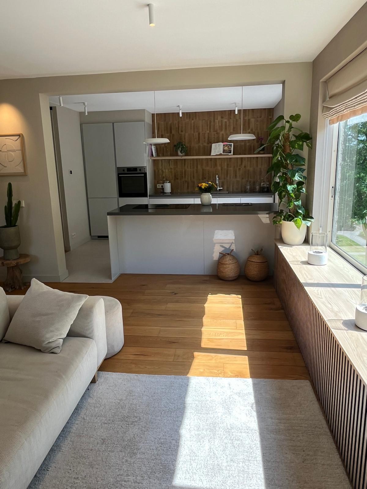 Kitchen and living overview with island cooktop and garden view
