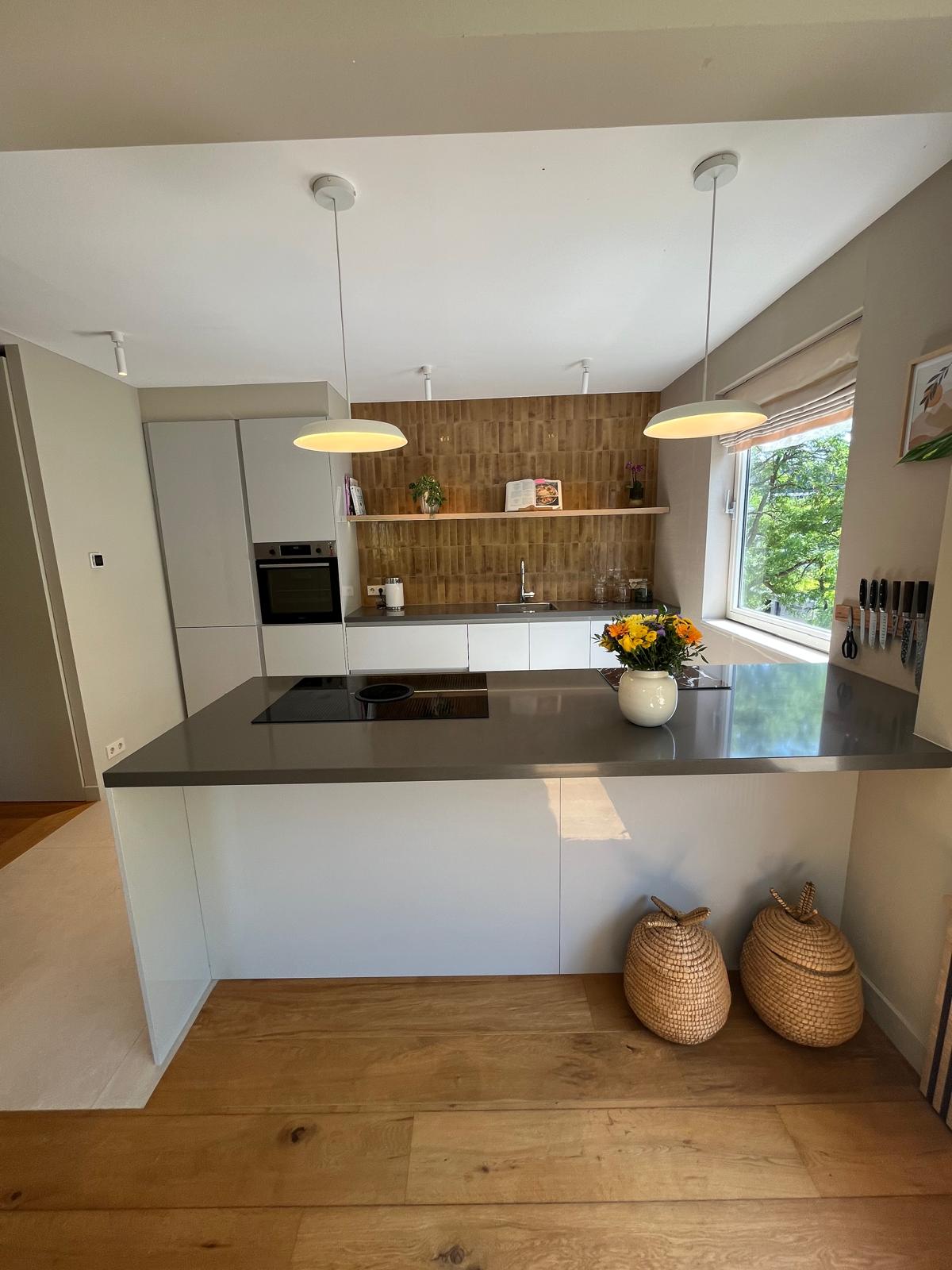 Handleless white kitchen with ochre vertical tile backsplash