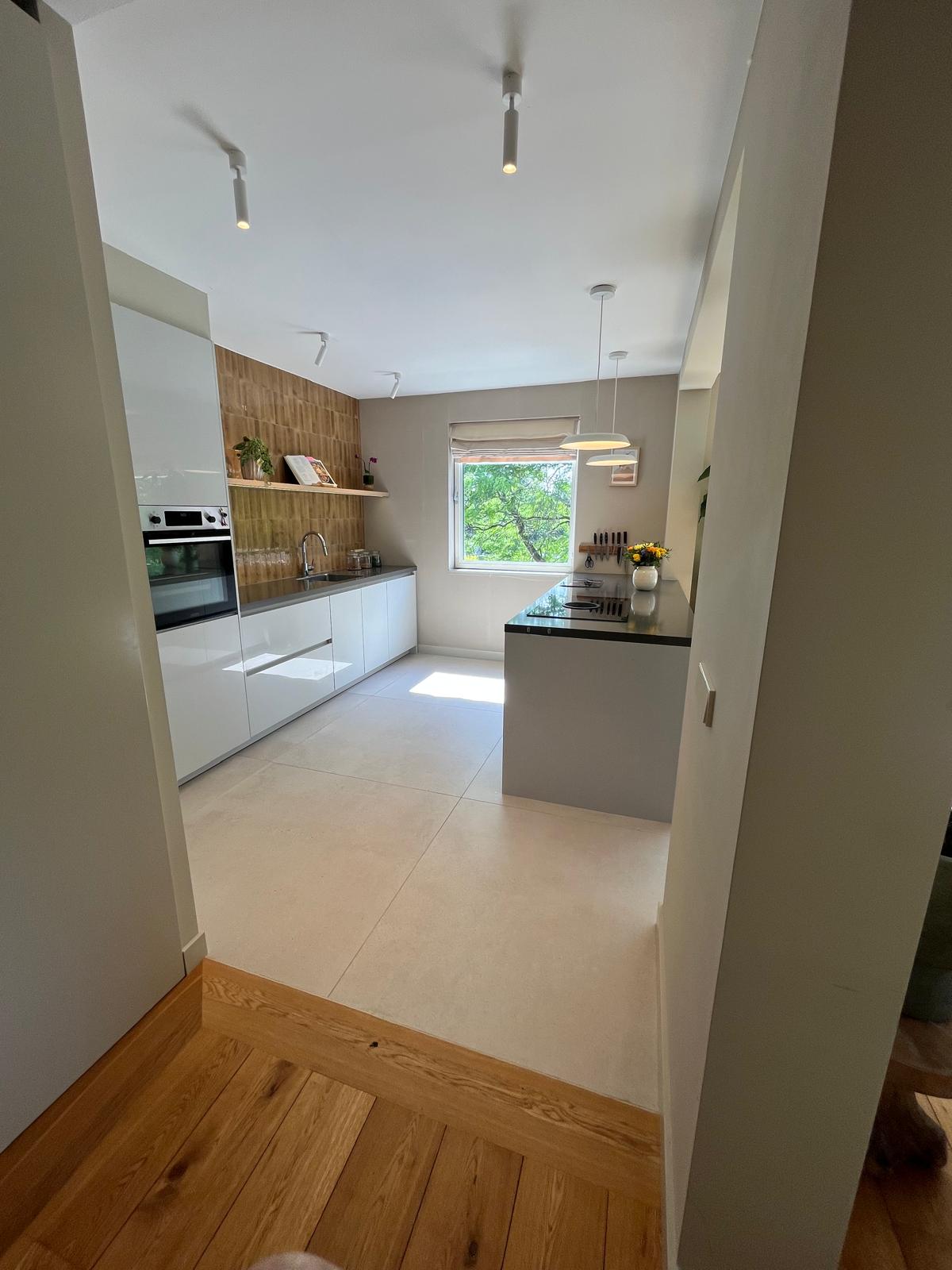 Kitchen with island, pendant lights and tile-to-oak floor transition