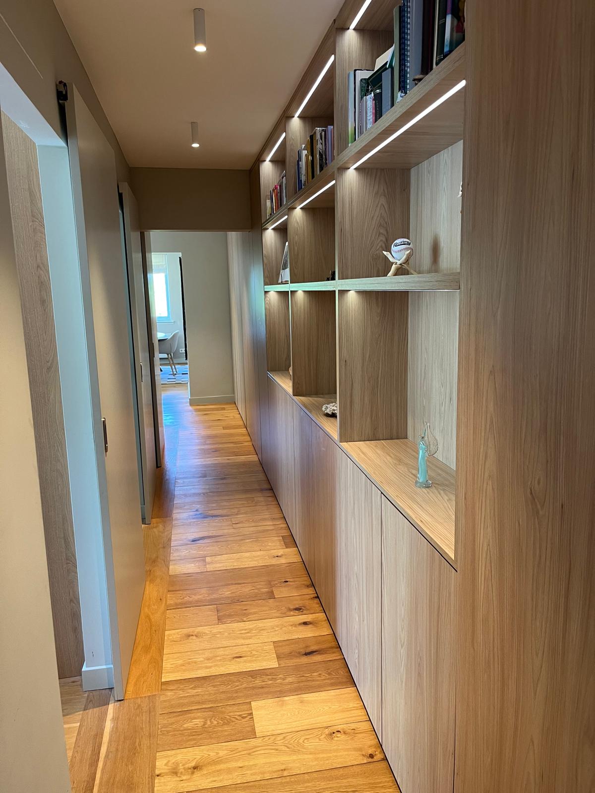 Long corridor lined with oak storage and pocket sliding door