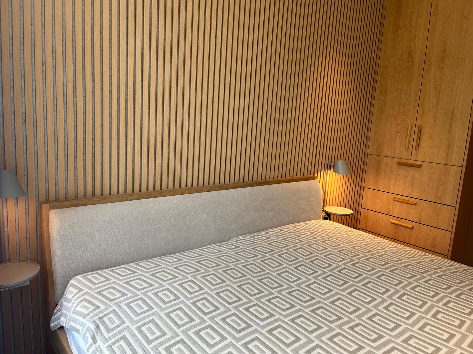 Bedroom with slatted feature wall and built-in oak wardrobe