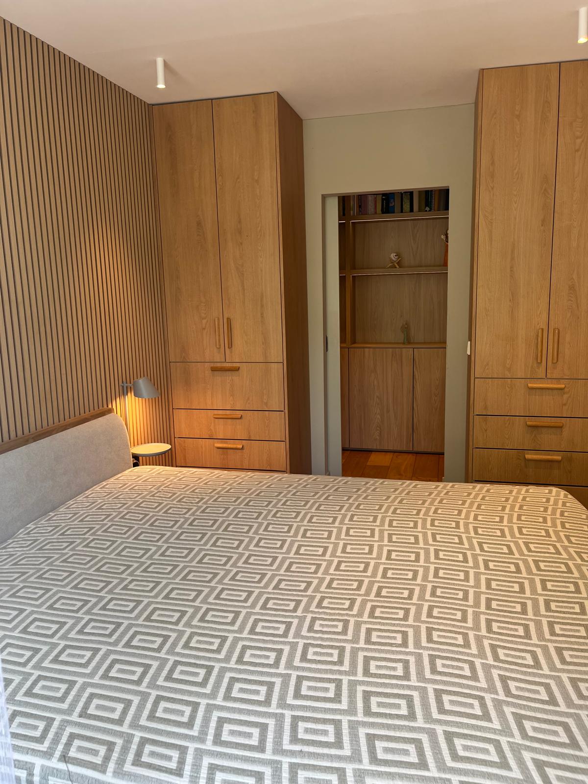 Master bedroom with paired wardrobes and slatted accent wall